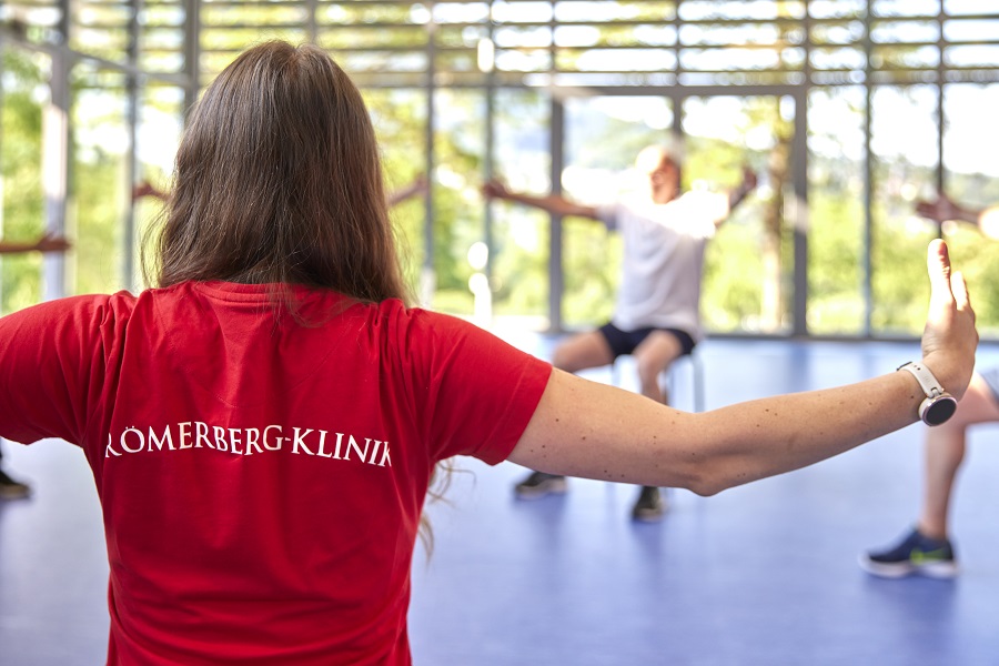 Eine Therapeutin mit großem Römerberg-Klinik Aufdruck auf dem Rücken ihres Shirts. Eine Therapeutin mit großem Römerberg-Klinik Aufdruck auf dem Rücken ihres Shirts.